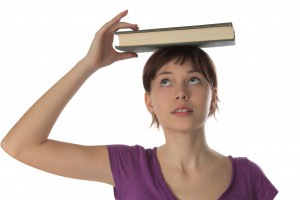 Beautiful girl  holds book on a head